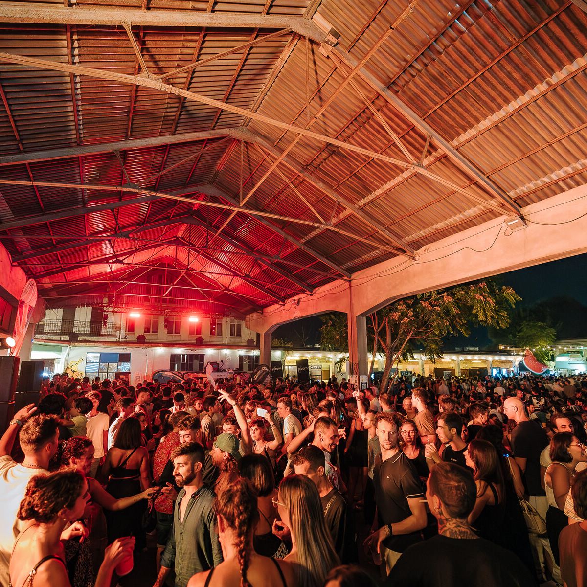 Folla del Gin & Tonic Festival sotto un capannone con luci rosse